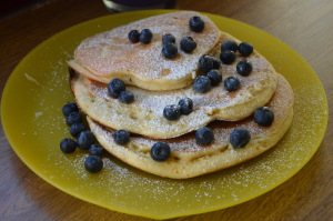 serve all blueberry pancakes on a big coloured plate